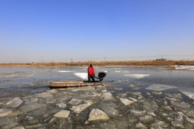 Luannan County - January 26, 2018: farmers use small boats to drive ice in the wild, Luannan, Hebei, Chin