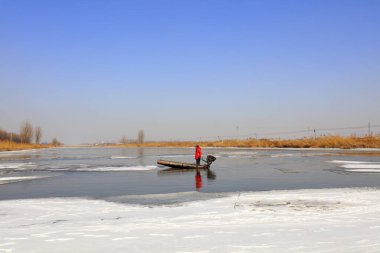 Luannan County - January 26, 2018: farmers use small boats to drive ice in the wild, Luannan, Hebei, Chin