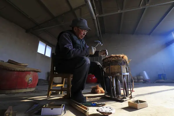 Luannan County - February 6, 2018: craftsman is working on the drum in workshops, Luannan, Hebei, Chin