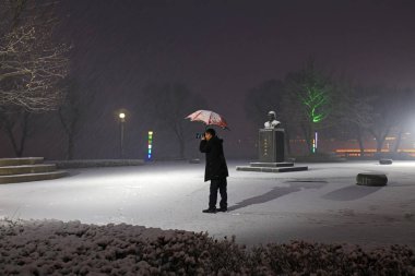 Luannan İlçesi - 7 Mart 2018: Bir fotoğrafçı karda, Luannan ilçesinde, Hebei eyaletinde, Çin 'de fotoğraf çekti.