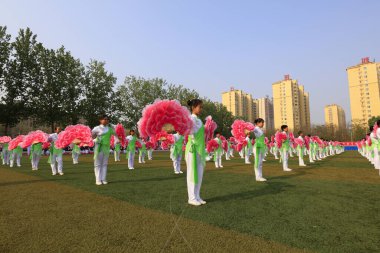 Tangshan City - 26 Nisan 2018: Tangshan City, Çin 'deki orta okul spor toplantısında büyük bir grup jimnastik performansı
