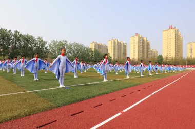 Tangshan City - 26 Nisan 2018: Tangshan City, Çin 'deki orta okul spor toplantısında büyük bir grup jimnastik performansı