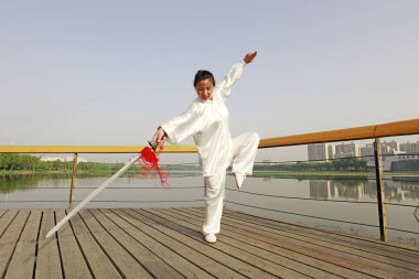 LUANNAN COUNTY, Çin - 27 Mayıs 2018: Bir kadın parkta Tai Chi Kılıcını uyguluyor, LUANNAN COUNTY, Hebei Eyaleti, Chin