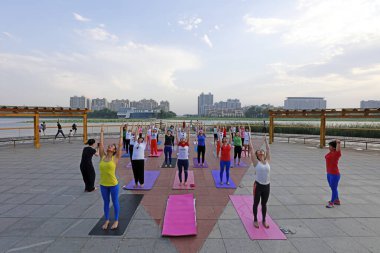 LUANNAN COUNTY, Çin - 30 Haziran 2018: Kadınlar LUANNAN COUNTY, Hebei Eyaleti, Çin 'de bir parkta açık hava yogası yapıyorlar