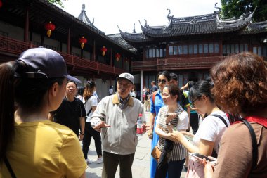Şangay, Çin - 2 Haziran 2018: Yaşlı bir eğitmen Yu Garden, Şangay, Çin 'de turistlere açıklıyor