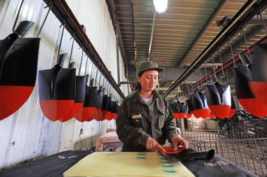 LUANNAN COUNTY, Hebei Eyaleti, Çin - 15 Nisan 2019: İşçiler çelik kürek üretim fabrikasının üretim hattında meşguller.