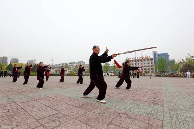 LUANNAN COUNTY, Hebei Eyaleti, Çin - 29 Nisan 2019: insanlar park meydanında Tai Chi Kılıcı kullanırlar.