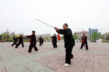 LUANNAN COUNTY, Hebei Eyaleti, Çin - 29 Nisan 2019: insanlar park meydanında Tai Chi Kılıcı kullanırlar.