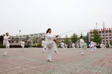 LUANNAN COUNTY, Hebei Eyaleti, Çin - 29 Nisan 2019: insanlar park meydanında Tai Chi Kılıcı kullanırlar.