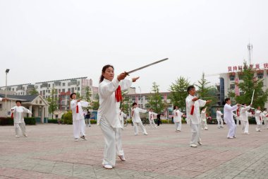 LUANNAN COUNTY, Hebei Eyaleti, Çin - 29 Nisan 2019: insanlar park meydanında Tai Chi Kılıcı kullanırlar.