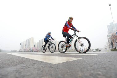 LUANNAN COUNTY, Hebei Eyaleti, Çin - 23 Kasım 2019: Bisikletçiler bir yol bisikleti yarışması sahasında ilerlemeye çalışıyorlar.