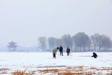 İnsanlar kışın donmuş nehirde oynarlar.