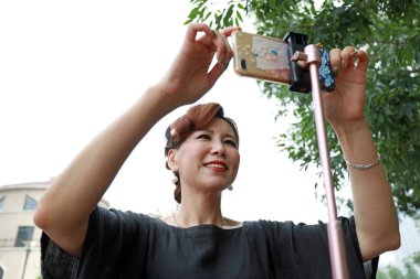 Luannan County, Çin - 9 Temmuz 2019: Bir kadın Çin 'in Hebei Eyaleti' ndeki Luannan County parkında canlı yayın yapıyordu.