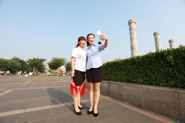 Luannan İlçesi, Çin - 12 Temmuz 2019: Bayanlar, Çin 'in Hebei Eyaleti Luannan İlçesi' nde elinde ulusal bayrak ile fotoğraf çekiyorlar