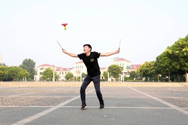 Luannan County, Çin - 12 Temmuz 2019: İnsanlar Diabolo 'yu Çin' in Hebei Eyaleti, Luannan County 'deki parklarda egzersiz yapması için sallıyor. Diabolo geleneksel Çin halk sporu yöntemlerinden biridir..