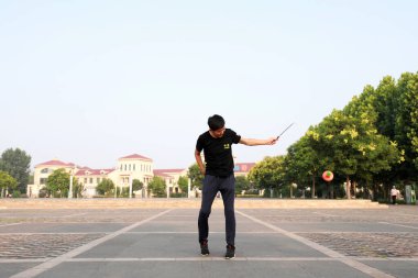 Luannan County, Çin - 12 Temmuz 2019: İnsanlar Diabolo 'yu Çin' in Hebei Eyaleti, Luannan County 'deki parklarda egzersiz yapması için sallıyor. Diabolo geleneksel Çin halk sporu yöntemlerinden biridir..
