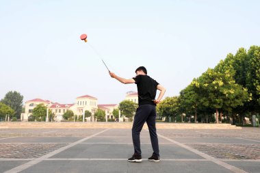 Luannan County, Çin - 12 Temmuz 2019: İnsanlar Diabolo 'yu Çin' in Hebei Eyaleti, Luannan County 'deki parklarda egzersiz yapması için sallıyor. Diabolo geleneksel Çin halk sporu yöntemlerinden biridir..