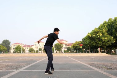 Luannan County, Çin - 12 Temmuz 2019: İnsanlar Diabolo 'yu Çin' in Hebei Eyaleti, Luannan County 'deki parklarda egzersiz yapması için sallıyor. Diabolo geleneksel Çin halk sporu yöntemlerinden biridir..