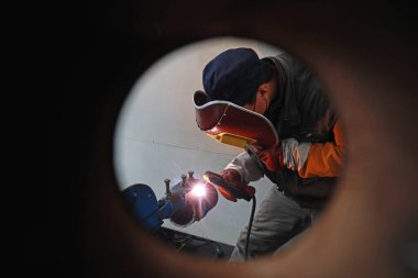 LUANNAN COUNTY, Hebei Eyaleti, Çin - 22 Kasım 2019: İşçiler üretim hattında metal parçaları kaynak yapıyorlar.