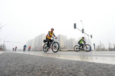 LUANNAN COUNTY, Hebei Eyaleti, Çin - 23 Kasım 2019: Bisikletçiler bir yol bisikleti yarışması sahasında ilerlemeye çalışıyorlar.