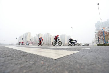LUANNAN COUNTY, Hebei Eyaleti, Çin - 23 Kasım 2019: Bisikletçiler bir yol bisikleti yarışması sahasında ilerlemeye çalışıyorlar.