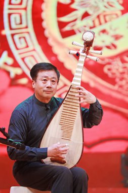 LUANNAN COUNTY, Hebei Eyaleti, Çin - 30 Aralık 2019: Sahnede çalan geleneksel Çin enstrümantal pipası.