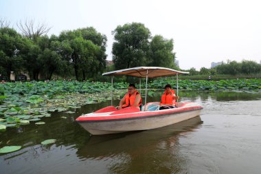Luannan İlçesi, Çin - 15 Temmuz 2019: Ziyaretçiler, Çin 'in Hebei Eyaleti, Luannan İlçesi, tekneyle lotus çiçeklerinin tadını çıkarıyorlar.