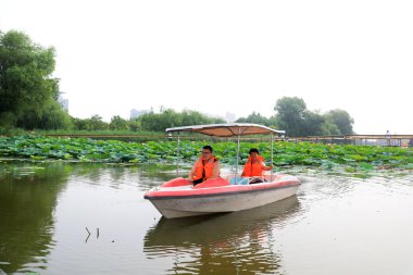 Luannan İlçesi, Çin - 15 Temmuz 2019: Ziyaretçiler, Çin 'in Hebei Eyaleti, Luannan İlçesi, tekneyle lotus çiçeklerinin tadını çıkarıyorlar.