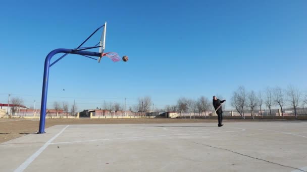 中国河北省阮南县 2020年12月31日 一名男子在篮球场上用铁锹从背后投出三分球 — 图库视频影像