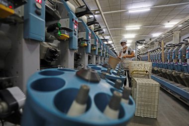 LUANNAN COUNTY, Hebei Eyaleti, Çin - 18 Mart 2020: Kadın işçi dönen fabrikada üretim hattıyla meşgul.