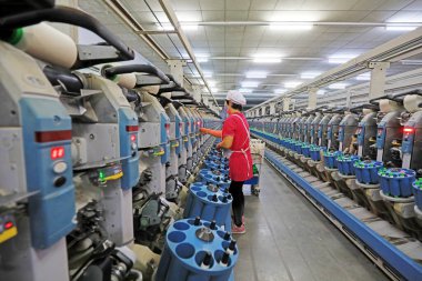 Kadın işçi dönen bir fabrikada üretim hattıyla meşgul..