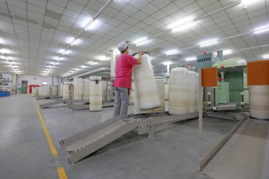 Kadın işçi dönen bir fabrikada üretim hattıyla meşgul..