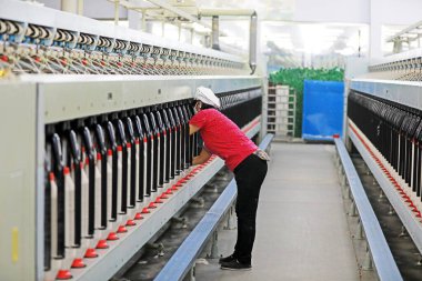 Kadın işçi dönen bir fabrikada üretim hattıyla meşgul..