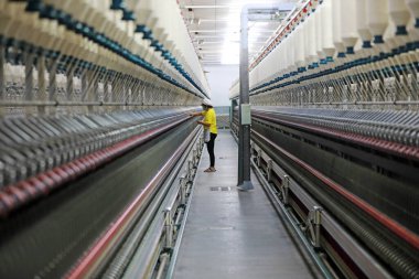 Kadın işçi dönen bir fabrikada üretim hattıyla meşgul..