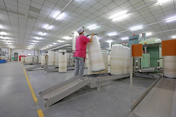 Kadın işçi dönen bir fabrikada üretim hattıyla meşgul..