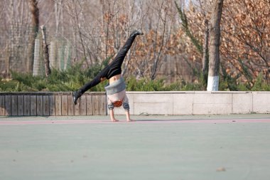 LUANNAN COUNTY, Hebei Eyaleti, Çin - 22 Mart 2020: Küçük bir kız yerde takla atıyor