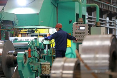 LUANNAN COUNTY, Hebei Eyaleti, Çin - 26 Mart 2020: İşçiler demir ve çelik fabrikasının şerit üretim hattında meşguller.