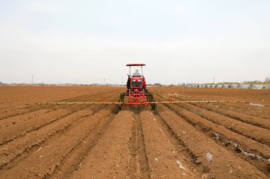 LUANNAN COUNTY, Hebei Eyaleti, Çin - 7 Nisan 2020: Çiftçiler tarlalara mantar ilacı püskürtmek için kendinden itişli sprey makineleri kullanıyorlar.