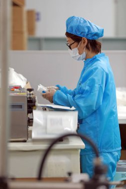 LUANNAN COUNTY, Hebei Eyaleti, Çin - 15 Nisan 2020: İşçiler tıbbi maske fabrikasının üretim hattında meşguller.