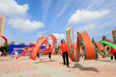 LUANNAN COUNTY, Hebei Eyaleti, Çin - 8 Ağustos 2020: İnsanlar parkta formda kalmak için renkli ipekleri sallıyor