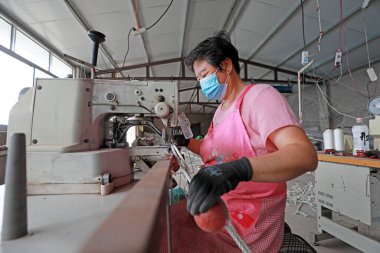 LUANNAN COUNTY, Hebei Eyaleti, Çin - 20 Ağustos 2020: işçiler fabrikalarda ağ şamandıraları dikmek için dikiş makineleri kullanıyorlar