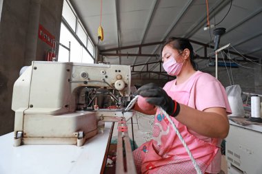 LUANNAN COUNTY, Hebei Eyaleti, Çin - 20 Ağustos 2020: işçiler fabrikalarda ağ şamandıraları dikmek için dikiş makineleri kullanıyorlar