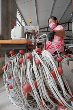 LUANNAN COUNTY, Hebei Eyaleti, Çin - 20 Ağustos 2020: işçiler fabrikalarda ağ şamandıraları dikmek için dikiş makineleri kullanıyorlar