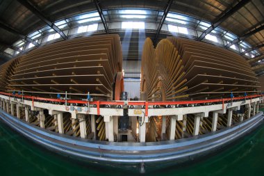  İşçiler üretim hattında plaka üretmek için makineleri kontrol ediyorlar