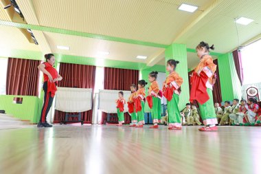 LUANNAN COUNTY, Hebei Eyaleti, Çin - 23 Eylül 2020: Bir anaokulu öğretmeni çocuklara anaokulunda Pekin Operası öğrenmeyi öğretiyor