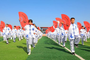 LUANNAN COUNTY, Hebei Eyaleti, Çin - 30 Eylül 2020: Ortaokul öğrencileri oyun alanında Taiji Fan pratik yapıyor