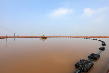 Çiğ tuz üretim ekipmanları Kuzey Çin 'deki bir tuz tarlasında kristalizatörde çalışıyor.