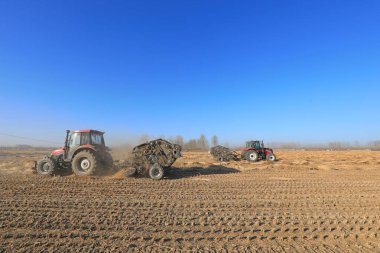 LUANNAN COUNTY, Çin - 24 Aralık 2020: çiftçiler pirinç pipetini sıkıştırmak ve onları bir çiftlikte, LUANNAN COUNTY, Hebei Eyaleti, Çin 'de paketlemek için tarım makineleri kullanıyorlar.