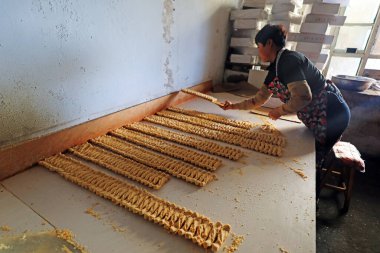 LUANNAN COUNTY, Hebei Eyaleti, Çin - 26 Ocak: İşlemciler aile atölyesinde fıstık ezmeli şeker paketliyorlar.