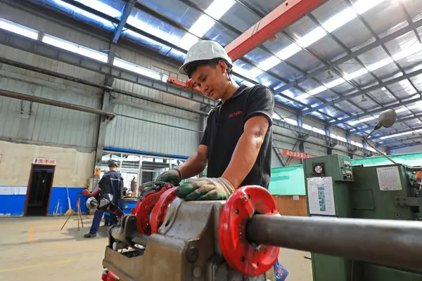 LUANNAN COUNTY, Hebei Eyaleti, Çin - 10 Temmuz 2020: işçiler üretim bandı üzerinde bir fabrikada çalışıyorlar